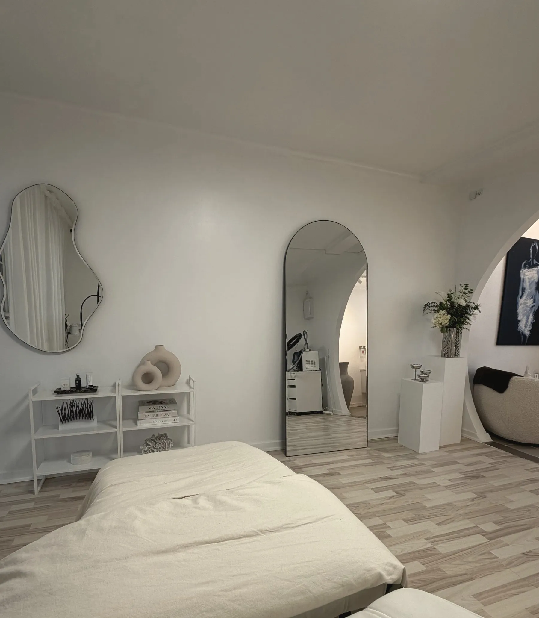 Behandlingsrummet hos Nuni Aesthetics med briks og buet spejl
